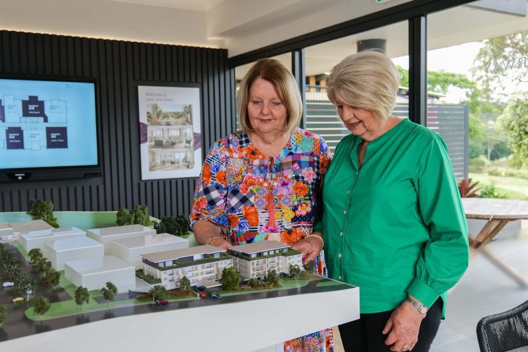 Old school friends and future Fairway residents, Cheryl and Denise looking at a model of their new home.